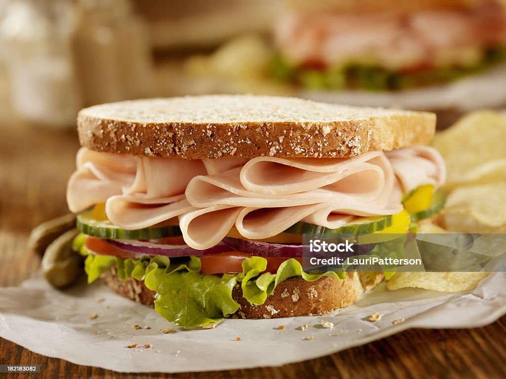 "Smoked Turkey Sandwich on Whole Grain Bread with Lettuce, Tomatoes, Cucumbers, Red Onions, Yellow Peppers and Potato Chips on the Side- Photographed on Hasselblad H3D2-39mb Camera"